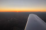 Airplane wing overlooking a sunset. Photo by Wade Jackson.