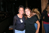 Two women in black tops standing together at a concert