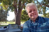 Don Simkovich sitting in front of laptop outdoors.