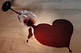 Spilled red wine into the shape of a heart