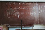 Math problem on a chalkboard.