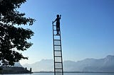 Someone on ladder hanging in the middle of the air. Getting to where you’re going, you have to make it, no matter what.