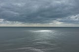 A moody sea and sky, with sun breaking through the clouds. taken on the south coast of the UK.