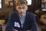 A man with the nametag Rich looking dejected as the person in front of them, at a speed dating event, is ringing the bell on the table, signalling that he should go away.