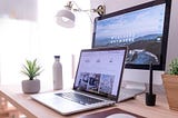Laptop and desktop monitor on home workspace desk