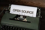 An Image by Markus Winkler of a typewriter typing out a paper that has Open-source boldly writing on it.