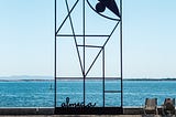 wrought iron sculpture with the ocean in the background