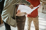 Three people looking at a map, discussing which way to go