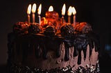A chocolate birthday cake with lighted candles on top