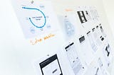 a stock image with a wall with high level ux process print-outs pinned