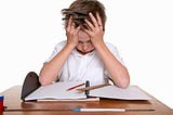 frustrated child with hands on head trying to do homework