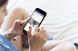 Young woman scrolling through social media on their phone.