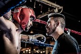 A coaching and a boxer in a boxing ring.