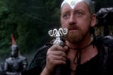 Merlin (Nicol Williamson) holding his wizard’s staff in Excalibur.