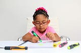 4-year-old brunette Latina girl with autism spectrum disorder ASD like Asperger, Rett and Heller draws at a desk, plays with colors alone antisocial