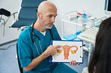 white man pointing at a picture of a womb