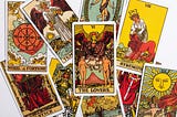 a jumbled pile of tarot cards in traditional art style with The Lovers card at the centre.