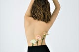 review view of woman with brown hair with flowers tucked in her pants