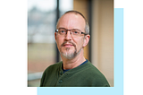 Picture of Rodney Kinney, Principal Machine Learning Engineer at AI2, wearing a green shirt and glasses and looking into the camera.