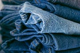 A pile of jeans in different shades of blue