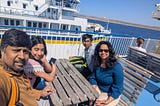 A picture of the author and her family at a table near the water.