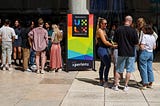 Attendees gathered outside the venue, next to the UXLx welcome sign.