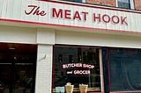 front of butcher shop called The Meat Hook