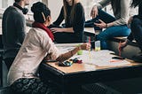 A group of young people meet around a table