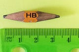 A 3.5 cm pencil sharpened at both ends lying next to a ruler