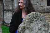 author standing by an old headstone