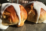 two hot cross buns with icing on a plate