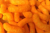 Lurid closeup of a bunch of bright orange cheese curls.