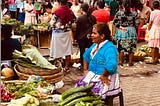 Ecuadoran woman sitting at her small fruit and vegetable stall in a local market.