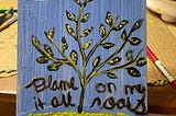 An encaustic painting of a diseased plant over a blue background, with the description “Blame it all on my roots.”