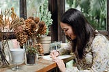 happy young woman writing at cozy desk