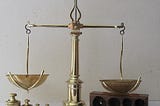 An old-fashioned two-pan balance scale, from Wikimedia by Jean Poussan