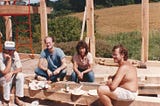 Author’s father and friends enjoying lunch while sitting in a house under construction