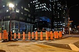 Orange cones lined up to cover two lanes of the road. Near CHUM and Old Montreal September 2021.