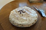 a chocolate cream pie with the mathematical pi symbol cast in chocolate sitting on top