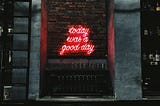 Neon sign on a brick wall reading “today was a good day”