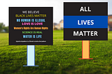 We Believe sign on grass and All Live Matter sign on grass