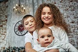 Three Children Wearing White Indoors Portrait