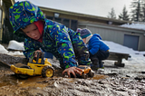 A child plays with toys in the mud at Play Frontier in Skamania County.