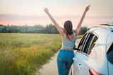 A carefree woman raises her arms skyward