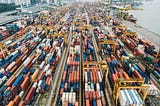 A busy port full of shipping containers, cranes, and huge boats