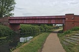 Water Made it Wet. A text based work by Lawrence Weiner — written along a metal bridge over the old canal.