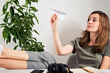 A woman throwing a paper airplane