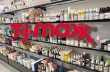 A well-organized beauty aisle at TJ Maxx with the brand logo atop the image