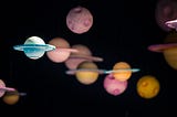 multi-colored planets and other celestial bodies floating within black space