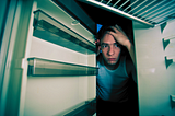 A man peering into his empty refrigerator.
